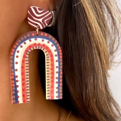 Brinco colorido grande em forma de arco com padrões em pontos e riscas