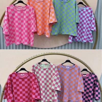 T-shirts xadrez coloridas penduradas em cabides