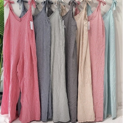 Vestidos compridos com padrão aos quadrados pequenos em várias cores pendurados numa estrutura branca