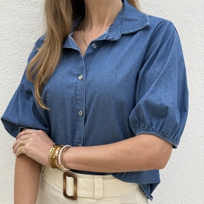 Blusa azul denim com botões e calças bege com cinto e fivela