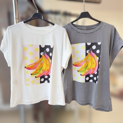 Duas t-shirts estampadas com bananas coloridas em cabides