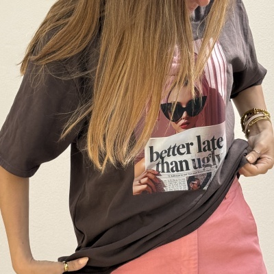 T-shirt preta com estampa frontal de mulher com óculos escuros e texto