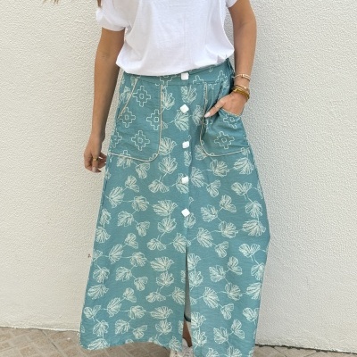 Saia longa azul com estampa de folhas e botões brancos ao centro