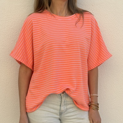 Camisola riscada laranja e rosa com calças claras