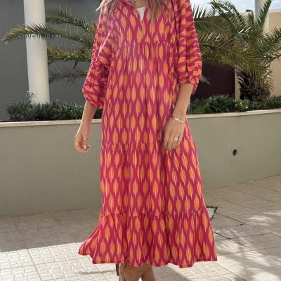Vestido comprido rosa e laranja com padrão geométrico, mangas 3/4 e tecido leve.