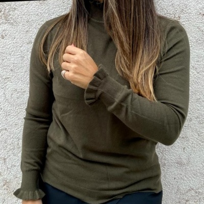 Camisola verde-oliva com gola e punhos folhosos usada por mulher