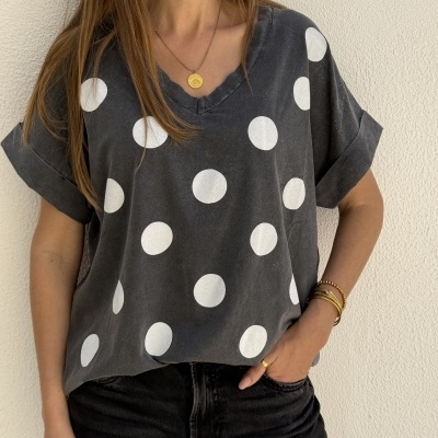 T-shirt cinza escuro com bolinhas brancas e gola em V com mangas dobradas