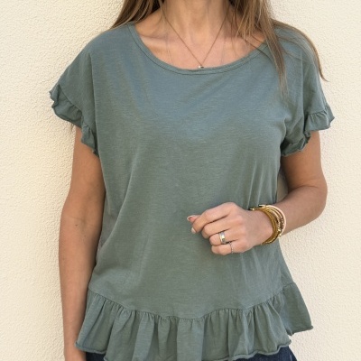 Blusa feminina verde claro com folhos na bainha e mangas, usada com calças jeans escuras.