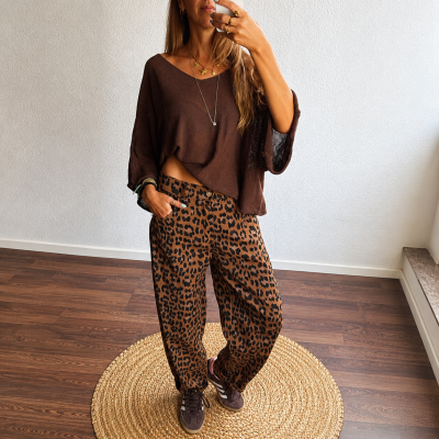 Mulher com camisola castanha e calças animal print