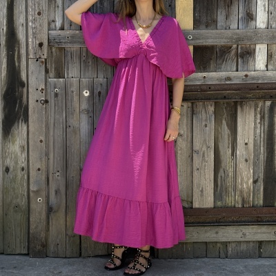 Vestido longo fúcsia com mangas estilo capa e sandálias pretas com tachas douradas