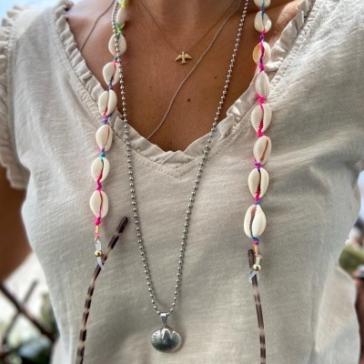 Cordão para óculos com conchas brancas e linhas coloridas em t-shirt branca