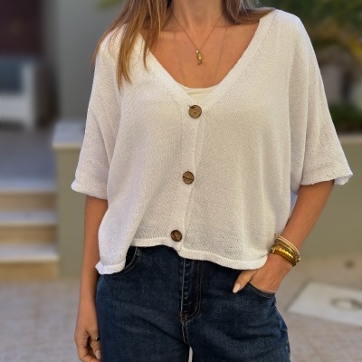 Camisola branca de malha com botões castanhos e calças jeans escuras