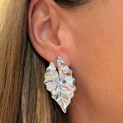 Brinco prateado em forma de folha na orelha de uma pessoa