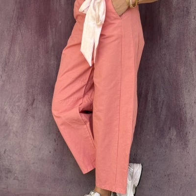 Calças rosa com cinto, top branco e ténis