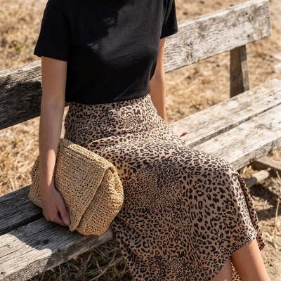 Saia animal print e t-shirt preta com bolsa de palha