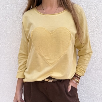 Sweatshirt amarela com coração em relevo e calças castanhas com acessórios