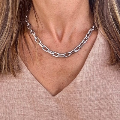 Colar de elos prateados usados por mulher com camisa bege