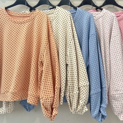 Cinco sweatshirts coloridas com padrão de corações penduradas