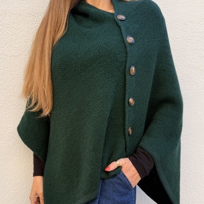 Poncho verde escuro de malha com botões visível num fundo branco