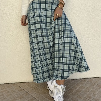 Saia xadrez azul e branca combinada com camisola branca e ténis brancos New Balance