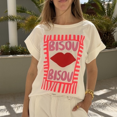 T-shirt branca com estampa vermelha e rosa BISOU e lábios ao ar livre com plantas ao fundo