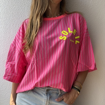 T-shirt rosa riscada com texto amarelo fluorescente e calças de ganga claras