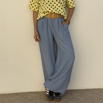 Calças largas azuis claras com cinto castanho, t-shirt amarela às bolinhas pretas, ténis pretos e brancos