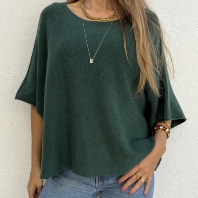 Camisola de malha verde escura com jeans azul claro e acessórios dourados