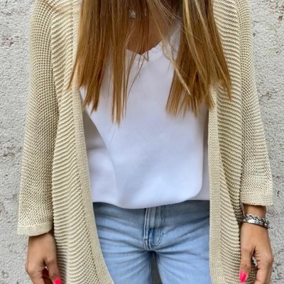 Cardigan bege estilo malha usado com blusa branca e calças de ganga azul claro