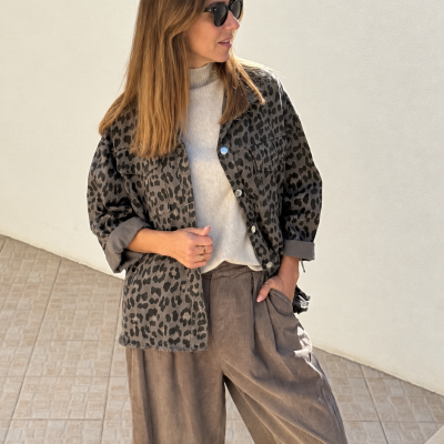 Mulher com casaco animal print e calças castanhas largas com ténis brancos