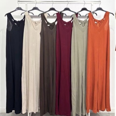 Seis vestidos compridos coloridos pendurados em cabides num varão