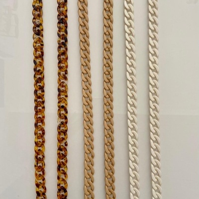 Seis correntes de plástico para óculos em várias cores dispostas verticalmente.