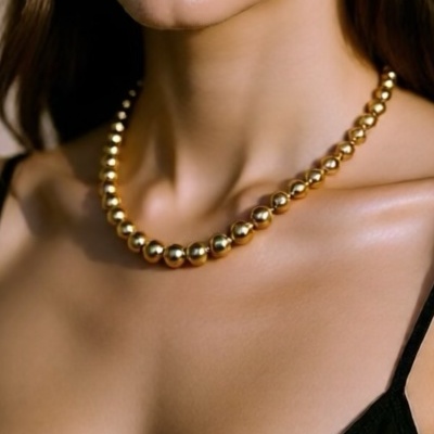 Colar de contas douradas em mulher com top preto