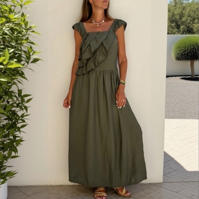 Vestido comprido verde-oliva com folhos no decote e sandálias castanho claro com tachas douradas.