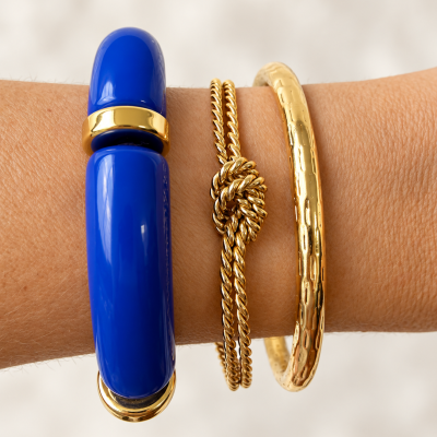 Pulseiras azul e douradas no braço