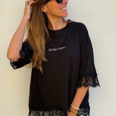 Blusa preta com renda nas mangas e barra e texto branco bordado no peito