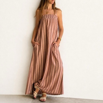 Vestido comprido rosa com riscas verticais usado por mulher com sandálias bege