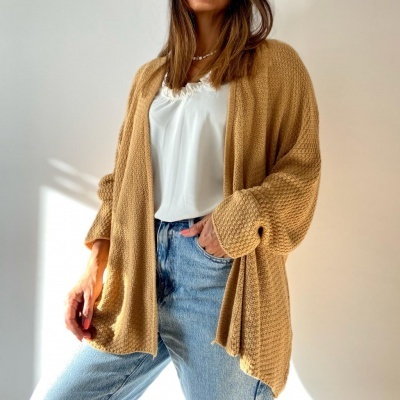 Mulher a usar casaco de malha castanho e jeans azuis