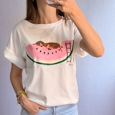 T-shirt branca com estampa de melancia e cão castanho deitado
