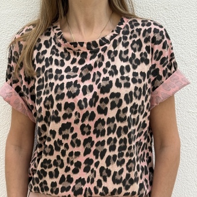 T-shirt animal print rosa e bege com calças rosa claro num fundo branco.
