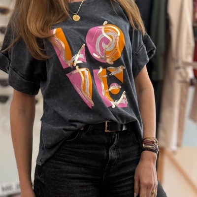 T-shirt preta com estampa colorida da palavra LOVE em tons de rosa e laranja