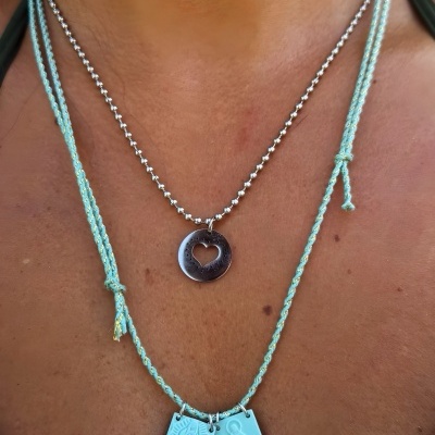 Colares com pendentes metálicos e azuis no pescoço