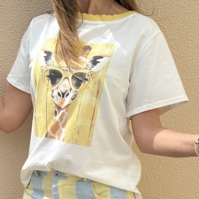 T-shirt branca com estampa de girafa usando óculos amarelos