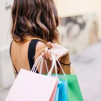 Mulher de costas com sacos de compras coloridos