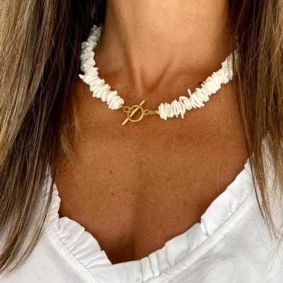Colar branco composto por pequenas conchas e fecho dourado em forma de barra e argola