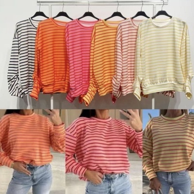 Cinco sweatshirts com riscas horizontais em diferentes cores penduradas e três imagens inferiores com detalhes das mesmas sweatshirts vestidas com jeans.