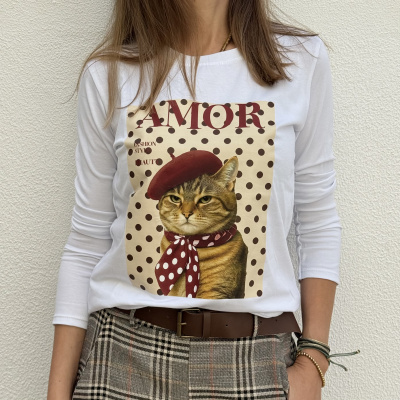 T-shirt branca com estampa de gato com boina e cachecol às bolinhas em fundo bege com bolinhas castanhas, texto AMOR