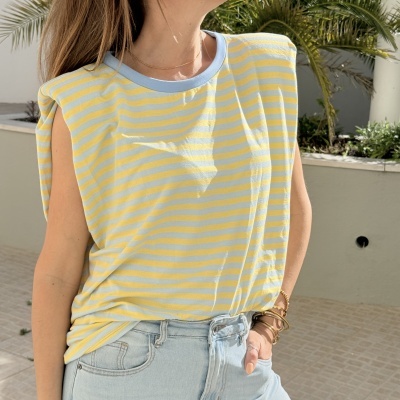 T-shirt sem mangas às riscas amarelas e cinza claro com ombreiras e calças de ganga azuis