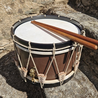 Tambor rústico com baquetas em superfície de pedra