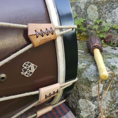 Tambor tradicional castanho com baqueta de madeira e pele